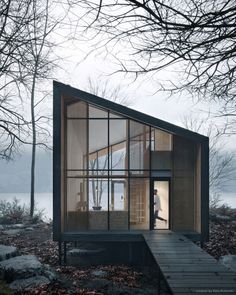 a small house in the woods with lots of trees and leaves on the ground next to it