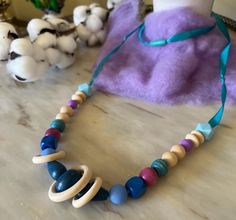 a necklace made out of wood and beads on a table next to some other items