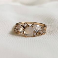 three stone ring sitting on top of a white cloth