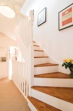 there is a vase with yellow flowers on the stairs in this house's entryway