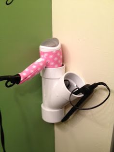 a pink and white umbrella hanging from the side of a wall next to a cup holder