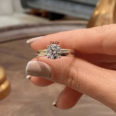 a woman's hand holding a diamond ring with the word teach written on it