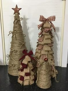 three burlap christmas trees with bows on them