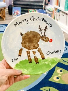 a hand holding up a plate with a reindeer on it and the words merry christmas charlotte