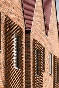 three windows are shown on the side of a brick building that is made out of bricks