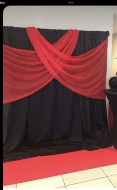 a black and red backdrop is on display in a room with white tile flooring