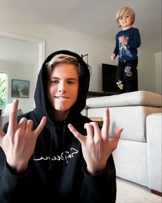 a young man in a black hoodie making the vulcan sign