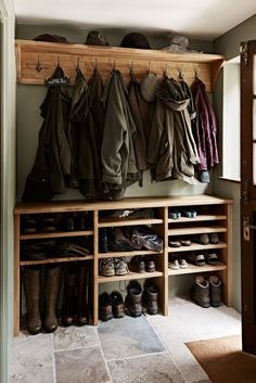 a coat rack with shoes and coats hanging on it