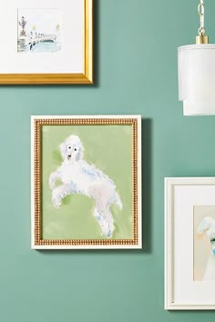 there are paintings on the wall and pictures on the wall above them, including a white poodle