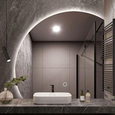 a bathroom with grey walls and marble counter tops, along with a white sink in the middle