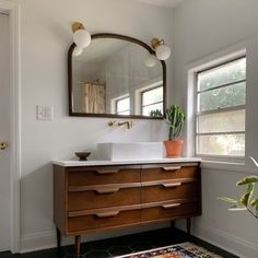 a bathroom with a sink, mirror and rug