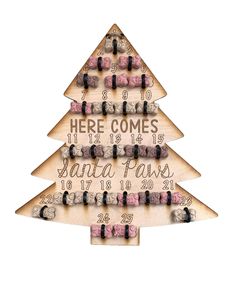 a wooden christmas tree with wine corks on it and the words here comes santa paws