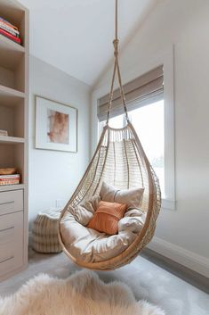 a hammock chair hanging from the ceiling in a room with white walls and carpet