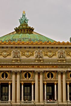 an ornate building with statues on the roof