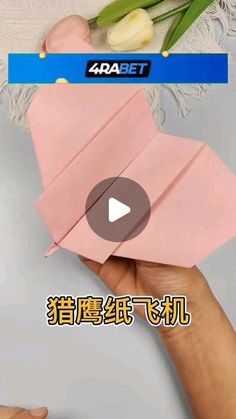 someone is holding an origami airplane in their hand and it looks like they are flying