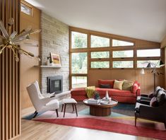 a living room filled with furniture and a fire place in front of a large window