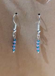 These are seed bead dangle earrings. I can do multiple color choices, let me know what you want and I can tell you if I have it. I can do post or fish hook style. If a post, I can do with plain or with a gem. both styles I can do multiple styles, gold, silver, bronze and others. Let me know what you are interested in. Dainty Beaded Earrings With Round Beads, Silver Drop Earrings With Tiny Beads, Dainty Dangle Beaded Earrings With Ear Wire, Dainty Earrings With Dangling Round Beads, Dainty Beaded Dangle Earrings, Dainty Adjustable Beaded Earrings, Beaded Dangle Earrings, Multiple Color, Etsy Earrings Dangle