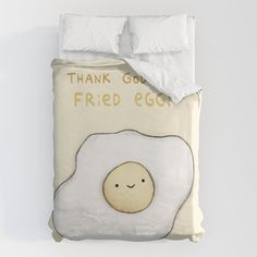 a bed with an egg on it and the words thank god, fried eggs written in gold