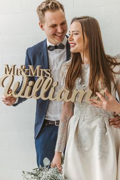 a man and woman standing next to each other in front of a sign that says mr and mrs william