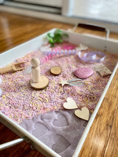 a tray filled with wooden buttons and other crafting supplies on top of a table