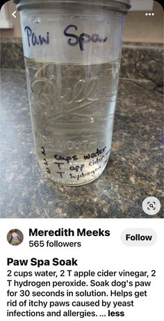 a cup filled with water sitting on top of a counter next to a phone screen