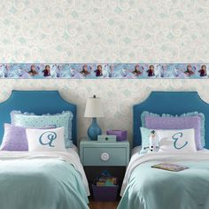 two twin beds with frozen princess bedding and blue headboards, one has the letter e on it