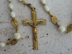 Religious antique French catholic vermeil gold plated rosary with white beads and cross crucifix with Holy Jesus Christ. This rosary has 53 white 'Hail Mary' beads and 6 beads for 'Our Father'. On the rosary center is Holy Mary. The length of the circle of rosary is 21,2 inches. ( 53 cm ) The length from the rosary center to the cross is 5,6 inches. ( 14 cm ) I bought the rosary on a brocante in France. I still have a lot other rosaries. If you don't have paypal, you can pay by bank transfer. I White Spiritual Cross Pendant Jewelry, White Crucifix Rosary With Miraculous Medal, Antique Gold Rosary As Gift, Vintage Gold Rosary With Crucifix, White Beaded Cross-shaped Rosary, Rosary With Faceted Beads And Crucifix, Classic Hallmarked Crucifix Jewelry, White Cross-shaped Rosary For Baptism, The Rosary