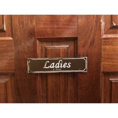 a door with a sign that says ladies in black on the front and side panels