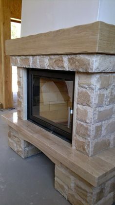 a stone fireplace with a wooden mantle in the middle