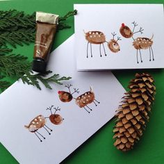 two cards with deer and pine cones on them, one has a tube of toothpaste