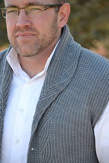 a man wearing glasses and a sweater vest