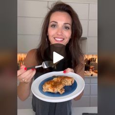 a woman holding a plate with chicken on it