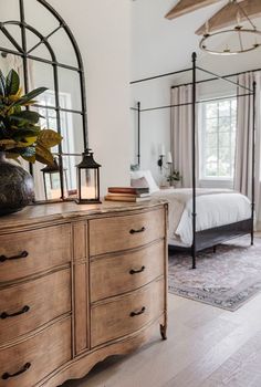 a bedroom with a bed, dresser and mirror