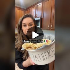 a woman is holding a bucket full of tortillas in her hands and the caption reads, flour tortillas