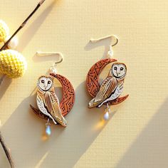 an owl is sitting on the moon earrings