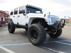 a white jeep parked in a parking lot