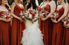 a group of women standing next to each other holding bouquets