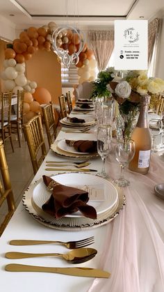 the table is set with gold and white plates, silverware, and champagne glasses