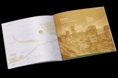 an open brochure showing the city's streets and roads in gold foil