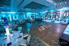 an empty dance floor with chairs and tables set up for a formal function at night