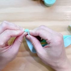 a person is cutting something with scissors on a wooden table next to other tools and supplies