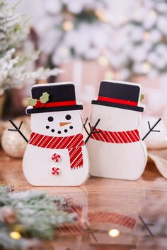 two snowmen standing next to each other on a table