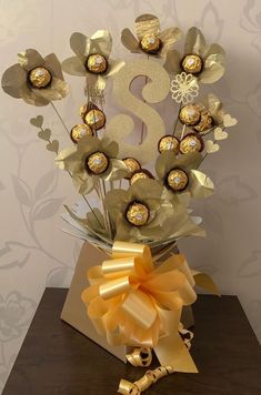 a vase filled with chocolates and flowers on top of a table