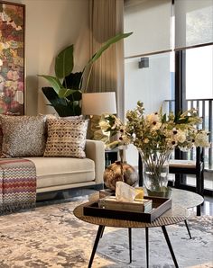 a living room filled with lots of furniture and flowers on top of a coffee table