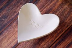 a white heart shaped dish with the words,'i love you'written on it