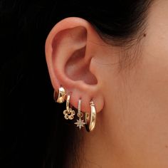 Lia Add a touch of artisanal elegance to your style. These hoops feature a handcrafted design, creating a unique and dainty appearance. Dangling from each hoop are petite flower charms, adding a delicate and charming element to the overall aesthetic. The solid gold construction enhances the timeless appeal of these earrings, making them a versatile choice for both casual and more refined looks. - Handmade- Solid Gold- Diameters: Outer 14 mm - Inner 11 mm- Size of the Flower Charm: 7.7 mm- Hoop T Cute Flower Earrings, Gold Plated Dainty Earrings With Flower Charm, Dainty Hoop Jewelry With Flower Charm, Trendy Gold Hoop Earrings With Flower Charm, Gold Flower Earrings With Charm, Gold Hoop Earrings With Flower Charm, Ear Stacks, Ear Ideas, Earring Stack