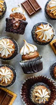 chocolate cupcakes with white frosting and star decorations on top are arranged in rows