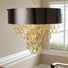 a chandelier hanging from the ceiling in a room with white walls and windows