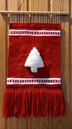 a red wall hanging with a white tree on it