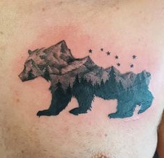 a man's chest with a bear and stars tattoo on the side of his chest